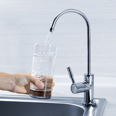 Filling glass of water in hand