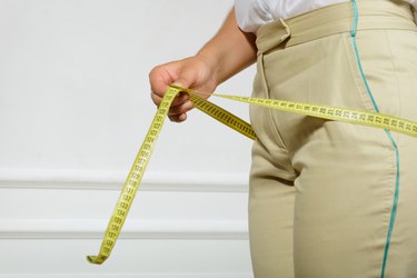 Woman measuring her hips by tape