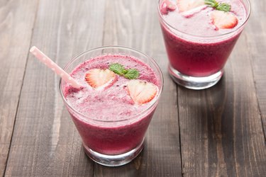 Strawberry smoothie in glass on wooden background