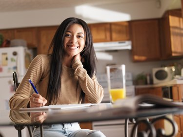 happy teen girl doing home work