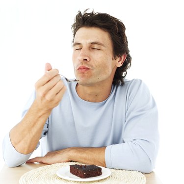 portrait of a man savoring a brownie with his eyes closed