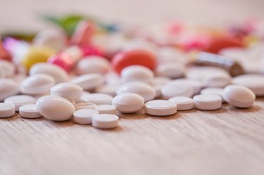 Pills and capsules on the wooden background