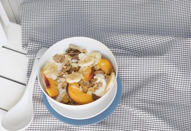 with bowl of cereal and fruit on orange tablecloth