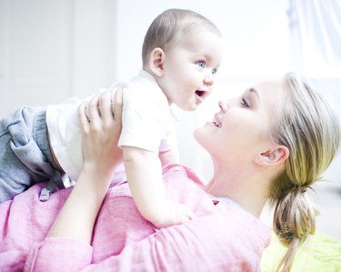 Teenage girl holding baby boy, close up