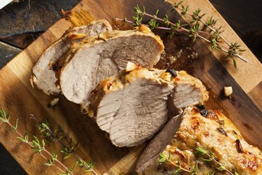 Homemade Hot Grilled Pork Tenderloin on a Cutting Board with Rosemary