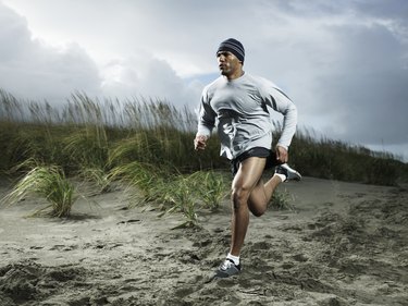 Muscular man running on beach