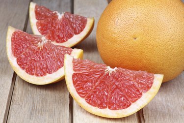 Sliced red grapefruit on a wooden background