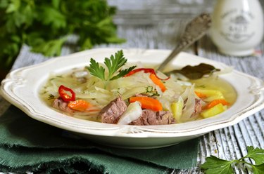 A bowl of cabbage soup on wooden table