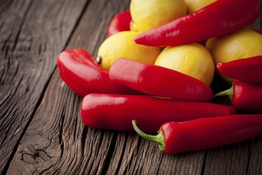 Fresh red chili and lemons on a wooden table