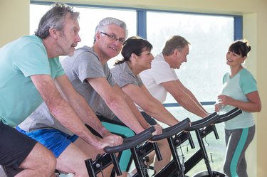 Group of seniors using spinning bikes