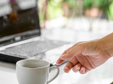 Coffee cup and laptop for business, Selective focus on coffee.