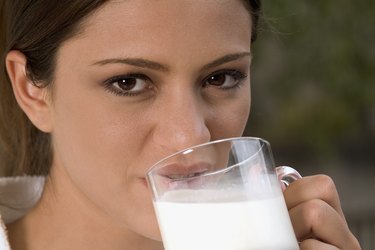 Close-up of a young woman drinking a glass of milk