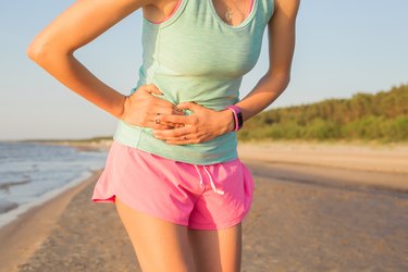 Woman runner having stomach cramps