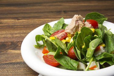 Fresh spinach salad with tuna and corn, cherry tomatoes