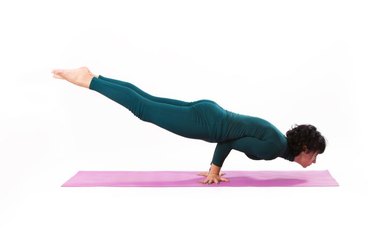 woman practice yoga peacock pose studio shot