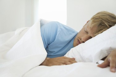 Young man sleeping in bed