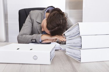 Exhausted Businesswoman Sleeping On Desk