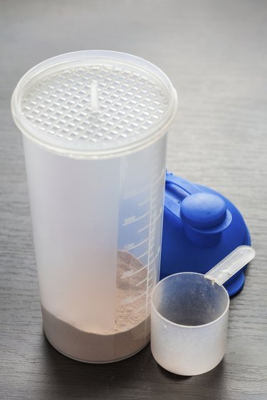 Empty scoop by chocolate whey isolate protein in shaker