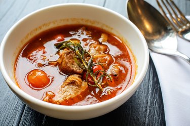 Pork stew in white bowl on wooden table