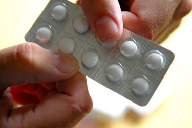 Holding a packet of tablets