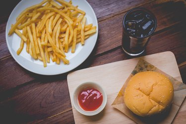 Hamburger, potato fries, cola drink. Takeaway food.