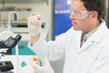 Male scientist analyzing pills in the laboratory