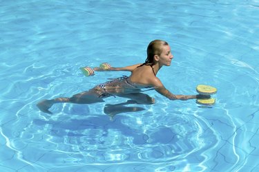 Aqua aerobic, woman in water with dumbbells