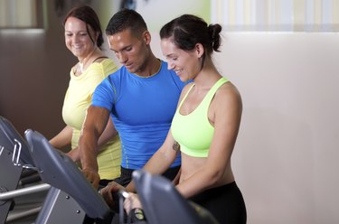 Personal trainer setting treadmill