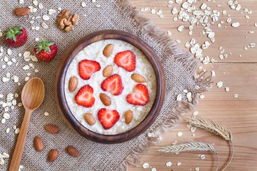 Healthy prepared oatmeal porridge breakfast with strawberries and nuts in