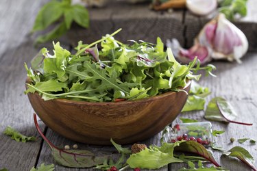 Green salad leaves in a wooden bowl