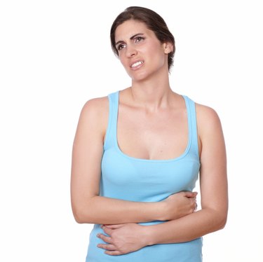 Pretty young woman on gym clothing having pain in stomach