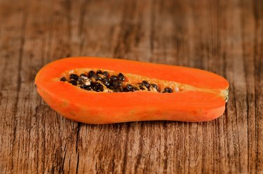 Sliced fresh papaya on wooden background