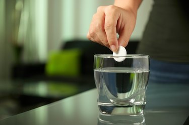 Sick Woman Puts Effervescent Tablet Aspirin In Glass Of Water
