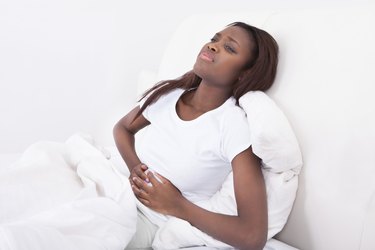 Woman Suffering From Stomachache In Bed