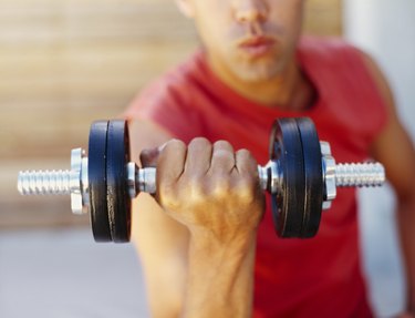 close-up of a young man exercising with a dumbbell