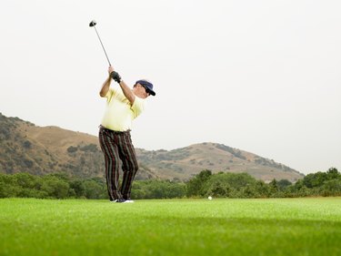 Mature golfer preapring to drive ball