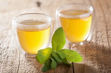 herbal sage tea with green leaf in glass cup