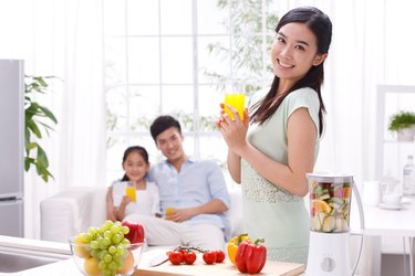 Family holding juice in kitchen