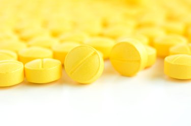 Closed up of small yellow medicine tablets (or pills)