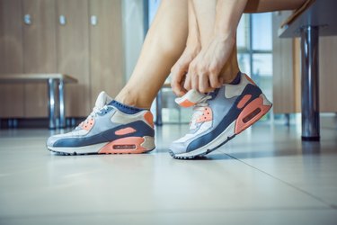 Sporty woman tying her shoelaces close up