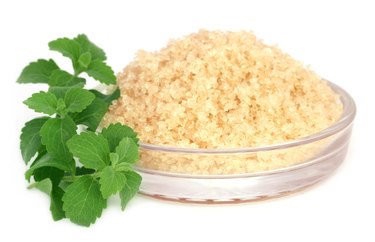 Coarse crystals of brown sugar with stevia leaves