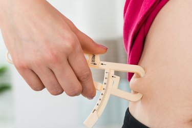 Female Hands Measuring Fat Belly