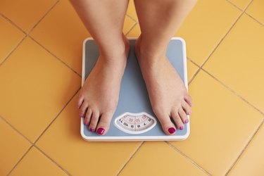 Pair of female feet on a bathroom scale