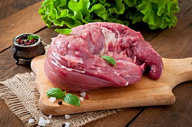 Piece of raw pork tenderloin on a wooden background