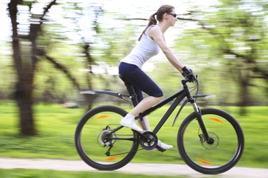 Image of woman riding bicycle in a green park