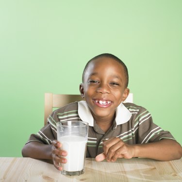 Portrait of African boy holding glass of milk
