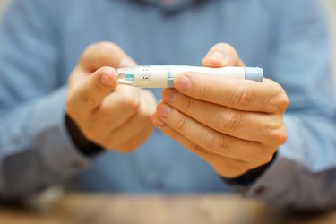 man is measuring the level of glucose in the blood