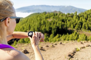 Cross country runner looking at sport watch