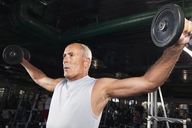 Mature man weight training in gym, low angle view