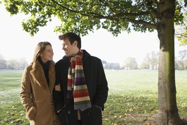Couple walking in park, smiling, autumn
